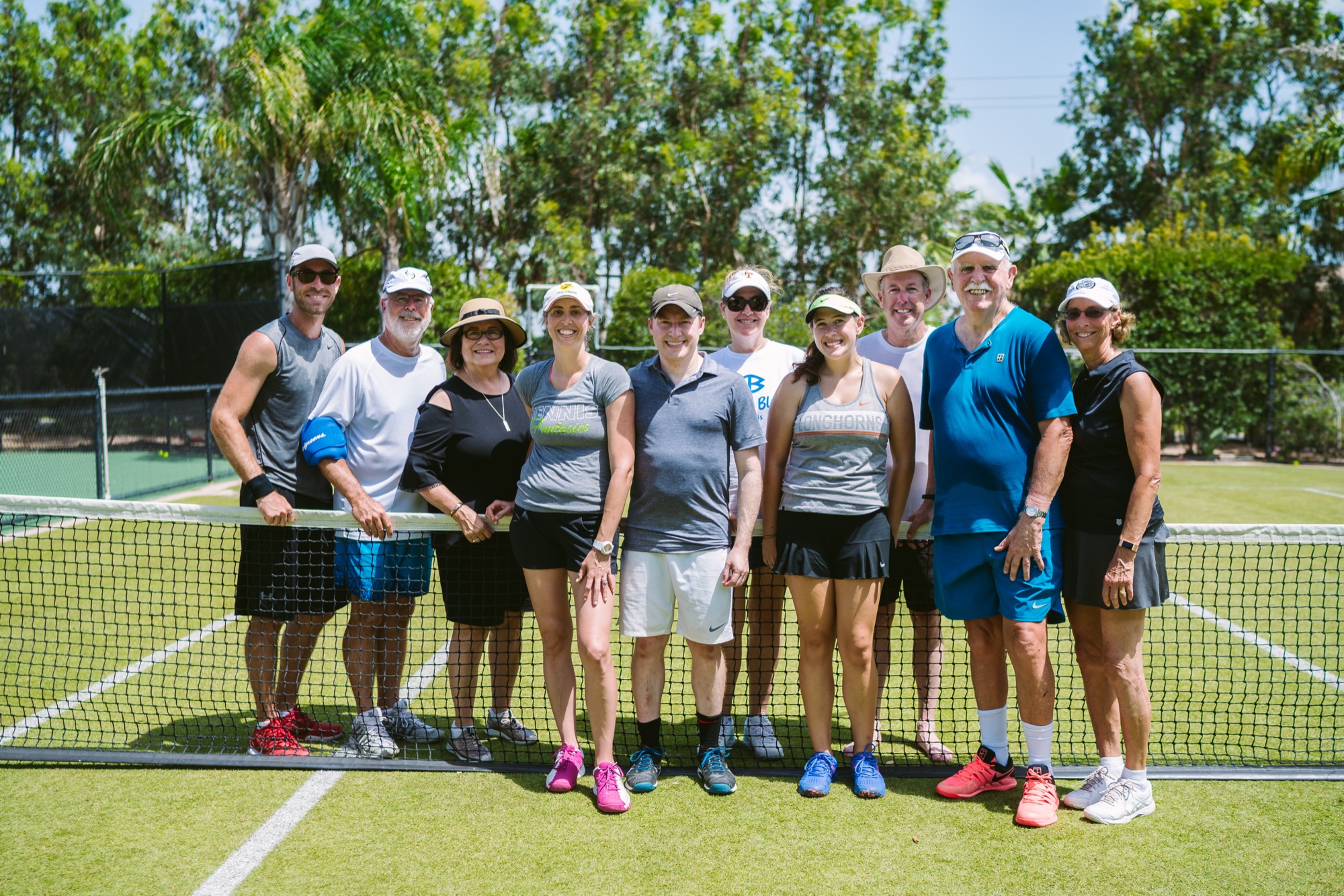 The group at the net on the grass court